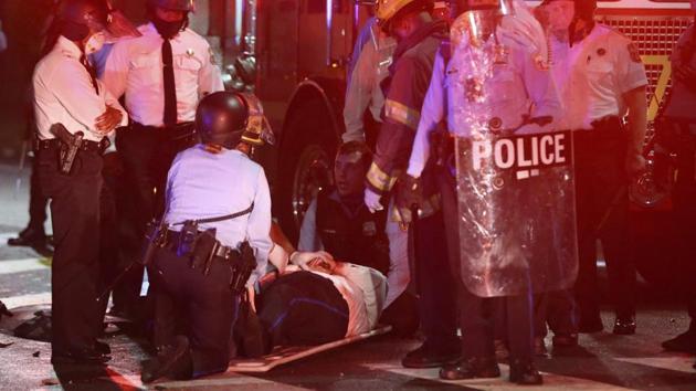 A police officer lies on the ground before being loaded into an ambulance on 52nd Street in West Philadelphia in the early hours of Tuesday. (AP) A police officer lies on the ground before being loaded into an ambulance on 52nd Street in West Philadelphia in the early hours of Tuesday. (AP)
