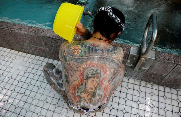 Construction worker Hiraku Sasaki, 48, washes his body at a Japanese public bath called a "sento", as he gets together with tattoo artist Asakusa Horikazu to pose for photographs in Tokyo, Japan, September 24, 2020. (REUTERS)