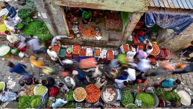 People stream past vegetable vendors in a market at Daryaganj in New Delhi on October 26. India also registered its sharpest fall in its daily novel coronavirus cases in three months with the country logging a 36,470 new infections in the last 24 hours. The overall caseload is now at 7,946,429, the Union Health Ministry’s dashboard showed on October 27. (Manvender Vashist / PTI)