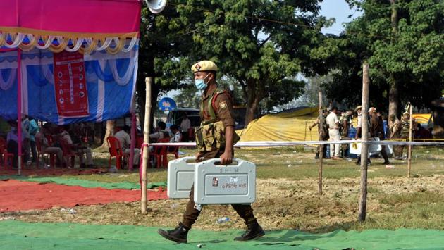 A security personnel carries Electronic Voting Machines (EVM) on the eve of Bihar Assembly elections, at Bharatpura near Patna on October 27. People from 71 assembly constituencies across 16 districts voted today during the first phase of Bihar Assembly elections. (Parwaz Khan / HT Photo)