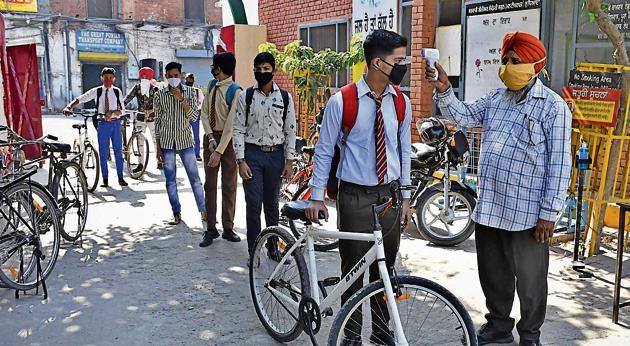 Students undergoing thermal screening outside Government Senior Secondary School, Multipurpose, on Shingar Cinema Road in Ludhiana on Wednesday.(Harsimar Pal Singh/HT)