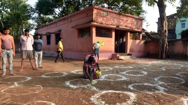 A worker marks out circles for social distancing on the eve of the first phase of Bihar Assembly elections in Paligung constituency on October 27. Voting began at 7 am today and continued until 4 pm in some constituencies and till 6 pm in others-- so that Covid-19 patients can vote in the last hour of the day. This is the first election that is being held amid the Covid-19 pandemic. (Parwaz Khan / HT Photo)