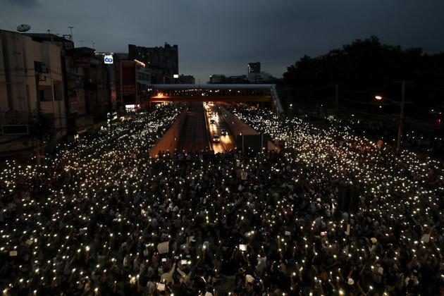 In this October 19, 2020, file photo, pro-democracy activists wave mobile phones with lights during a demonstration at Kaset intersection, suburbs of Bangkok, Thailand (AP Photo/Sakchai Lalit, File)