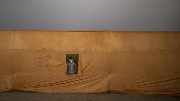 A man looks out from behind a curtain during the Dussehra festival celebrations in New Delhi on October 25. The number of cases in Delhi has started to rise in October as the government have scaled up the more reliable RT-PCR tests. On October 28, over 17,000 RT-PCR tests were conducted in the city for the very first time, HT reported. (Altaf Qadri / AP) A man looks out from behind a curtain during the Dussehra festival celebrations in New Delhi on October 25. The number of cases in Delhi has started to rise in October as the government have scaled up the more reliable RT-PCR tests. On October 28, over 17,000 RT-PCR tests were conducted in the city for the very first time, HT reported. (Altaf Qadri / AP)