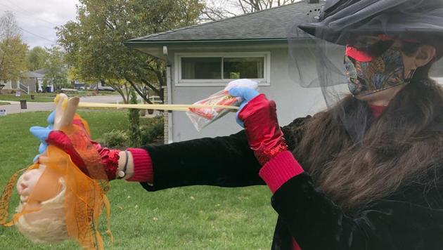 Julie Schirmer demonstrates the slingshot she’ll use to deliver Halloween candy from afar at her home in Columbus, Ohio. (AP) Julie Schirmer demonstrates the slingshot she’ll use to deliver Halloween candy from afar at her home in Columbus, Ohio. (AP)
