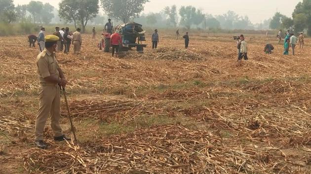 Members of the woman’s family at their field under police protection, in Hathras village. (HT photo) Members of the woman’s family at their field under police protection, in Hathras village. (HT photo)