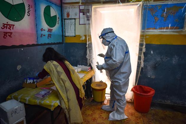 A health worker in PPE coveralls readies to collect a swab sample for coronavirus testing, at Khajuri Khas in New Delhi (Photo by Sanchit Khanna/ Hindustan Times)