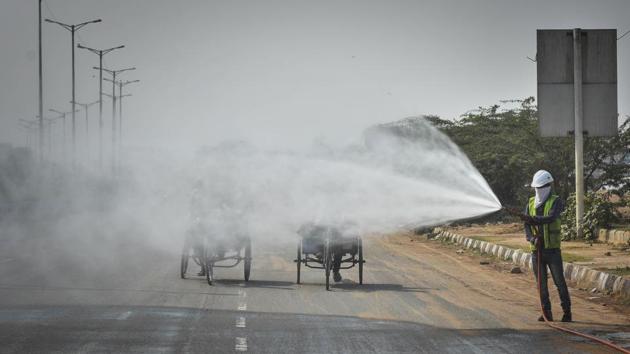 A Municipal Corporation of Delhi (MCD) worker sprinkles water on a road at Jahangirpuri in New Delhi on October 27. Just over half of Delhi’s 36 air-quality monitoring stations had readings above 400 on October 29. According to Reuters, authorities said that it can affect healthy people and seriously harm any who are already ill. (Sanchit Khanna / HT Photo)