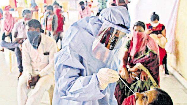 A health worker at a Covid-19 testing centre. The villages that have not reported a single virus case are located in the interiors.(HT PHOTO)