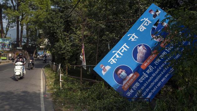 Motorists drive past a fallen billboard on coronavirus awareness in Dharmshala on October 29. India has one of the world’s lowest death rates with fatalities at 1.5% of total Covid-19 cases and the slowing number of new infections has been regularly highlighted. Authorities are nevertheless cautious of a new surge after Diwali, which is among the country’s most important religious festival, on November 14. (Ashwini Bhatia / AP)