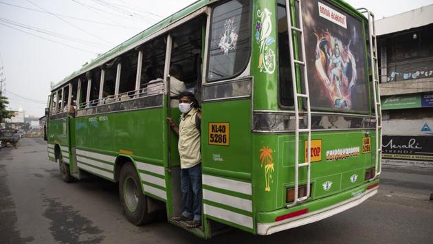 A man wearing a face mask prepares to alight from a bus in Kochi on October 29. Dr. T. Jacob John, a retired virologist, told the AP that the ongoing festival season was likely to increase the speed of the viral spread, resulting in localized outbreaks where people gathered without masks and didn’t adhere to social distancing. (R S Iyer / AP)