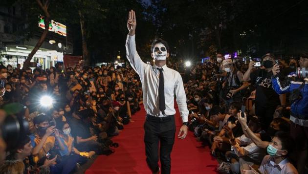 Pro-democracy protesters perform on a mock “red carpet” fashion show billed as a counterpoint to a fashion show being held by one of the monarchy’s princesses nearby in Bangkok, Thailand.(Associated Press)