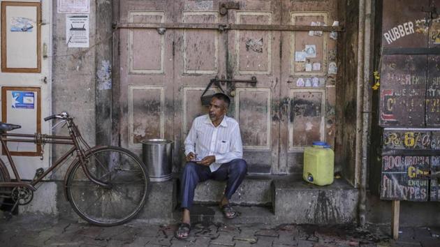 A man sits outside a closed store in Mumbai.(Bloomberg File Photo)
