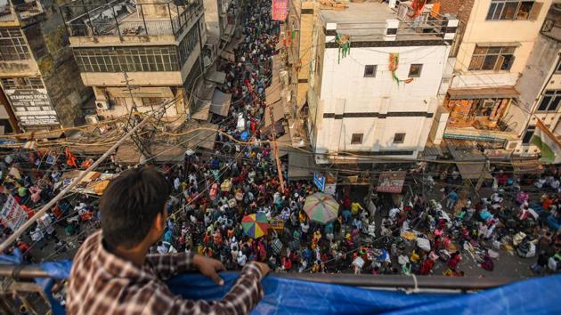 A man looks on to a large crowd of shoppers at Sadar Bazar in New Delhi on October 28. With coronavirus (Covid-19) cases on the rise in Delhi, thousands of people are thronging the city’s prominent markets for festive shopping weeks ahead of Diwali, while compromising social distancing norms. (Amal KS / HT Photo)