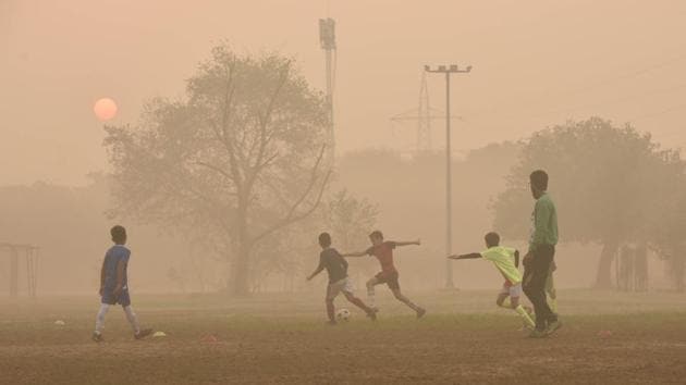 Children playing football on a hazy morning in New Delhi.(Vipin Kumar/HT Photo)