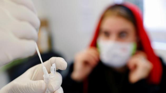 A medical worker performs a fast PCR test in a test container in Austria.(REUTERS) A medical worker performs a fast PCR test in a test container in Austria.(REUTERS)