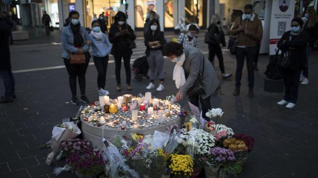 A woman lights a candle in front of the Notre Dame church in Nice, France on Friday.(AP Photo) A woman lights a candle in front of the Notre Dame church in Nice, France on Friday.(AP Photo)