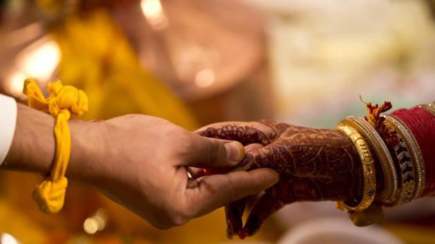 A bride and groom holding hands during wedding ceremony in this representative image.(Getty Images)