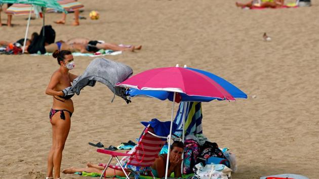 FILE PHOTO: A woman wearing a protective mask is seen on the beach in Las Palmas, Canary Islands, Spain, August 13, 2020.(REUTERS)