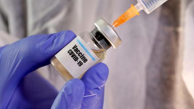 A woman holds a small bottle labeled with a "Vaccine COVID-19" sticker and a medical syringe in this illustration taken April 10, 2020 (REUTERS/Dado Ruvic/Illustration/File Photo)