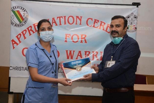 Dr Anil Luther, medical superintendent of CMCH, presenting a certificate of appreciation to an employee of the nursing department on Saturday.(HT photo)