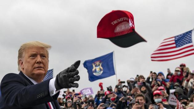 President Donald Trump tosses a cap during a campaign stop in Waterford Township, Michigan.(AP) President Donald Trump tosses a cap during a campaign stop in Waterford Township, Michigan.(AP)
