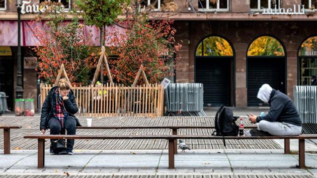 People seated distantly on a bench in Strasbourg, on October 30. There are a handful of exceptions, such as being allowed out for one hour of exercise a day within a 1 kilometer of home, to go to medical appointments, to a place of work, or to shop for essential goods. Restaurants and cafés are shuttered, apart from those that offer takeout. (Patrick Hertzog / AFP)