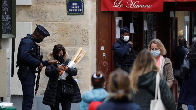 A police personnel checks a person for valid permission to be out in public, on the first day of the second national lockdown, in Paris on October 30. According to a poll by Odoxa-Dentsu Consulting for France Info and Le Figaro, seven out of 10 people in France are in favour of the new lockdown, which is scheduled to last a month. Travel between regions has also been limited. (Charles Platiau / REUTERS)