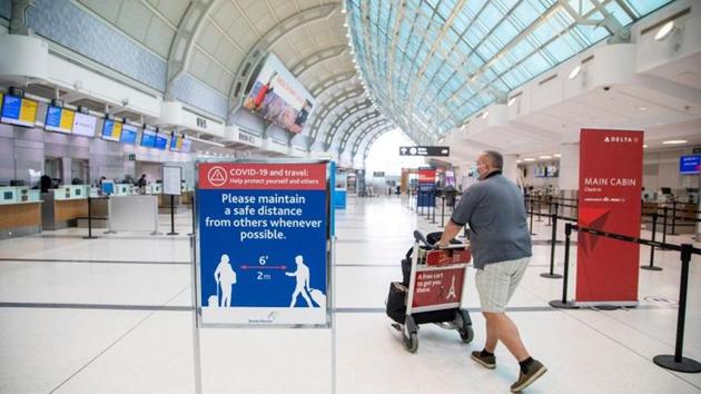 FILE PHOTO: A man pushes a baggage cart wearing a mandatory face mask as a "Healthy Airport" initiative is launched for travel, taking into account social distancing protocols to slow the spread of the coronavirus disease (Covid-19) at Toronto Pearson International Airport in Toronto, Ontario, Canada June 23, 2020.(REUTERS)