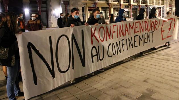 Demonstrators hold a banner reading “No nationwide lockdown” in Hendaye on October 30. Some angry citizens also took to the streets of Paris late on October 29 for an unauthorised protest to condemn the new measures as overly drastic. (Bob Edme / AP)