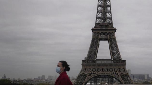 A woman walks near the Eiffel Tower in Paris, on the first day of a new month-long nationwide lockdown across France, on October 30. From midnight, France’s 65 million people were largely confined to their homes, needing written statements to leave, in the latest drastic measure to curb a disease that has infected more than 45 million people worldwide and killed nearly 1.2 million. (Thibault Camus / AP)