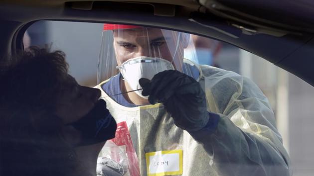 Cody Tupen, a firefighter with the Puget Sound Regional Fire Authority, performs a deep nasal nose-swab Covid-19 test at a King County Covid-19 testing site in Auburn, south of Seattle, Wednesday.(AP Photo)