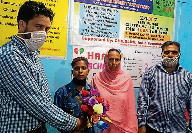 Poonch deputy commissioner Rahul Yadav with the minor boy and his family.(HT Photo)