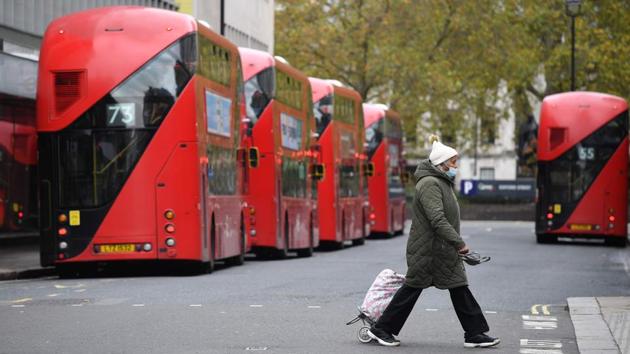 A pedestrian wearing a mask walks past parked buses in London on November 1. The UK recorded 21,915 confirmed coronavirus cases on October 31, taking the total since the pandemic erupted in the country to beyond a million. The country’s death toll is up to 46,555. (Justin Tallis / AFP)