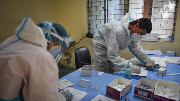 Health workers in PPE coveralls at work during sample collection for coronavirus testing at Hari Nagar in New Delhi on Saturday. (Sanchit Khanna/HT Photo) Health workers in PPE coveralls at work during sample collection for coronavirus testing at Hari Nagar in New Delhi on Saturday. (Sanchit Khanna/HT Photo)