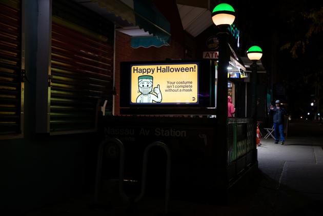 An ad at a subway entrance reminds commuters to wear masks on public transit on Halloween during the outbreak of the coronavirus disease in Brooklyn, New York, U.S., October 31, 2020. (REUTERS/Caitlin Ochs)