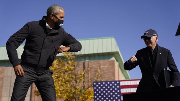 Democratic presidential candidate Joe Biden and former President Barack Obama greet each other at a rally at Northwestern High School in Flint, Michigan on October 31.(AP)