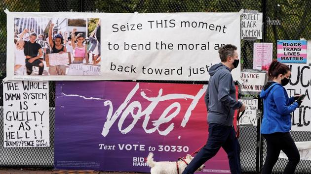 Pedestrians walks past a vote sign on a security fence ahead of Election Day near the White House in Washington, DC, US on October 31, 2020. (Reuters Photo) Pedestrians walks past a vote sign on a security fence ahead of Election Day near the White House in Washington, DC, US on October 31, 2020. (Reuters Photo)