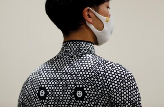 An employee of online fashion retailer Zozo Inc. poses for a photograph as he demonstrates the company's Zozosuit 2, a 3D body measurement suit, at their Tokyo office in Tokyo, Japan.(REUTERS)
