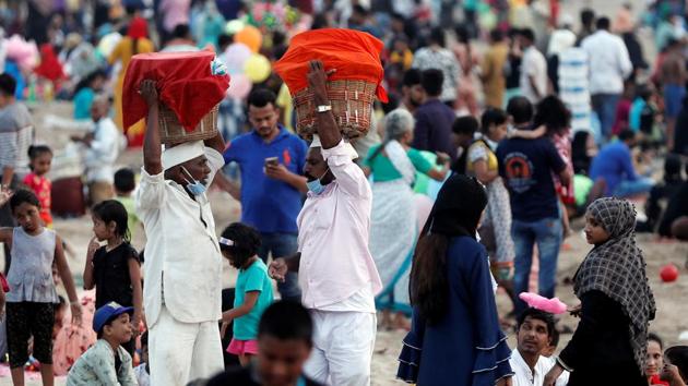 Ice-cream vendors seen interacting at a crowded beach in Mumbai on November 1. Active cases in Maharashtra have fallen steadily and stood at 123,585 on October 31, down from 2.59 lakh a month ago on September 30. (Francis Mascarenhas / REUTERS)