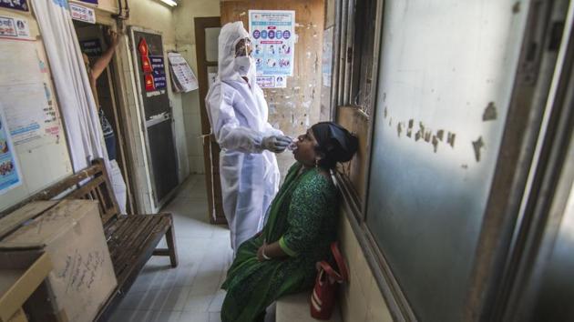 A health worker collects a swab sample from a woman to test for coronavirus infection at Trombay in Mumbai on October 31. Maharashtra’s Covid-19 recovery rate had improved to 89.9%, as of October 31. (Pratik Chorge / HT Photo)