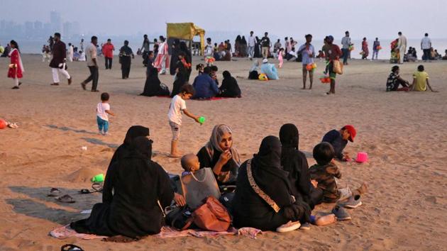 People relax on a beach in Mumbai on October 30. The month-on-month average daily tests being conducted in Maharashtra came down significantly to 70,393 in October from 88,209 in September. (Niharika Kulkarni / REUTERS)