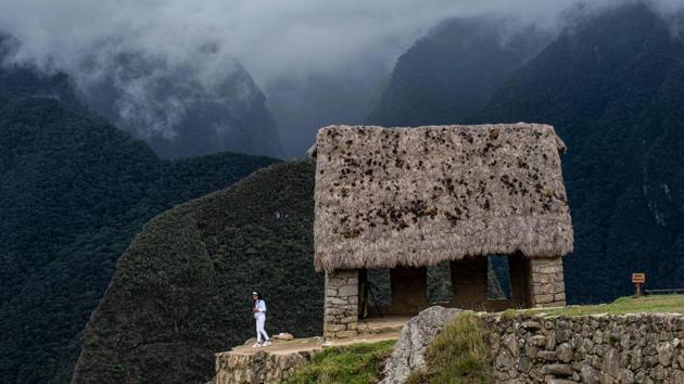 A tourist explores of the archaeological site of Machu Picchu on November 1. The ruins of the Inca settlement, abandoned and overgrown by vegetation, were rediscovered in 1911 by the American explorer Hiram Bingham and declared a UNESCO World Heritage site in 1983. (Ernesto Benavides / AFP)