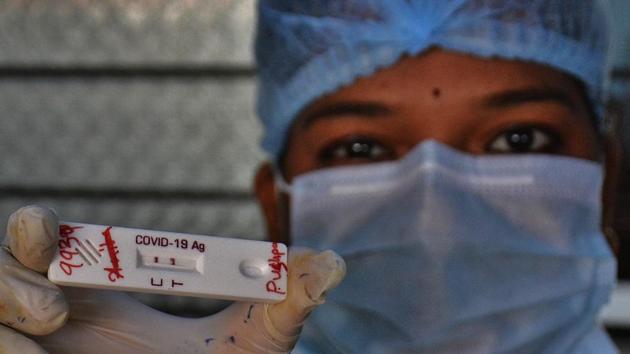 A health worker shows a Covid-19 antigen test slide at a testing centre in Thane on October 31. 60,577 Covid-19 tests were conducted across Maharashtra between October 30 and 31 at a positivity rate of 9.16%, against the cumulative positivity rate of 18.72%, HT reported. (Praful Gangurde / HT Photo )