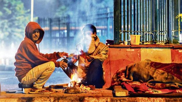 People sit next to a fire at Nizamuddin on Monday. (Amal KS/HT photo) People sit next to a fire at Nizamuddin on Monday. (Amal KS/HT photo)