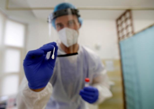 A medical student, wearing protective equipment prepares to collect a swab sample from a person at a coronavirus disease (Covid-19) testing center.(Reuters)