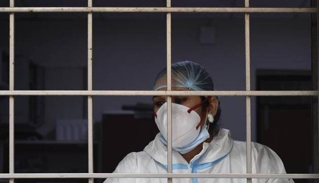 A health worker looks out from a window during sample collection for coronavirus testing, in Amar Colony, New Delhi, India, on Monday, November 2, 2020. (Photo by Vipin Kumar/ Hindustan Times) A health worker looks out from a window during sample collection for coronavirus testing, in Amar Colony, New Delhi, India, on Monday, November 2, 2020. (Photo by Vipin Kumar/ Hindustan Times)