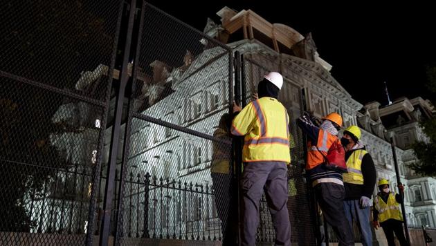 Construction workers set up additional fencing near the White House in Washington, DC on November 2. (Bloomberg) Construction workers set up additional fencing near the White House in Washington, DC on November 2. (Bloomberg)