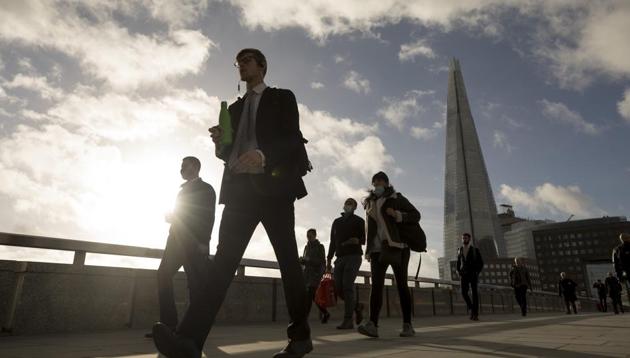 Commuters cross London Bridge in view of The Shard in London on November 2 ahead of a partial lockdown in UK.(Bloomberg)