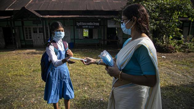 A school principal distributes masks to students as schools in Assam reopen after being closed for months due to coronavirus pandemic in Guwahati on November 2. On November 3, the country also lodged 38,310 fresh infections within 24 hours, the lowest single-day tally seen in the last week. (Anupam Nath / AP) A school principal distributes masks to students as schools in Assam reopen after being closed for months due to coronavirus pandemic in Guwahati on November 2. On November 3, the country also lodged 38,310 fresh infections within 24 hours, the lowest single-day tally seen in the last week. (Anupam Nath / AP)